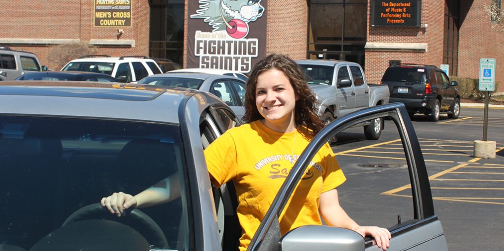 female smiling standing next to car