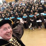 Sr. Arvid Johnson smiling with graduates